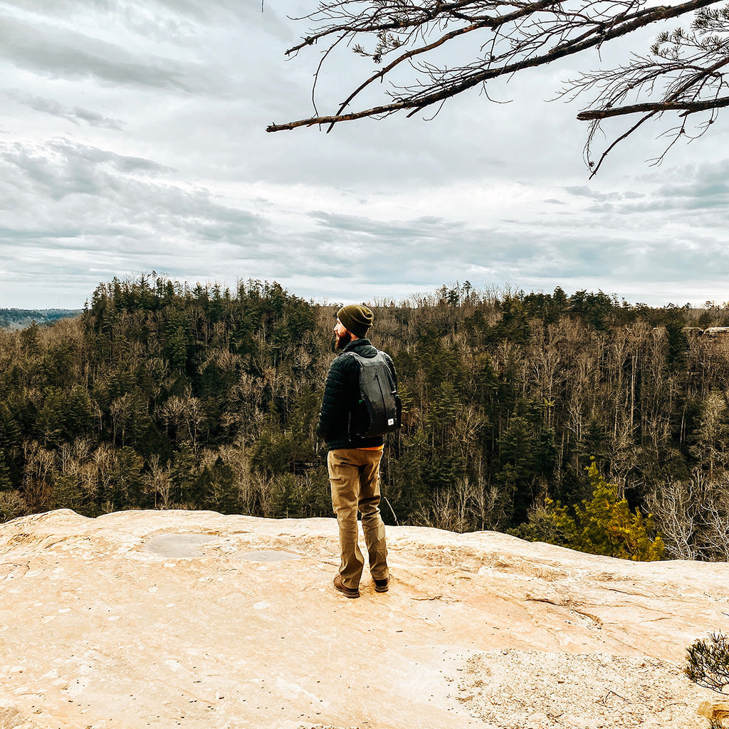 Owner of Weatherbeard standing on a cliff in Red River Gorge, Kentucky, embracing the rugged beauty of nature